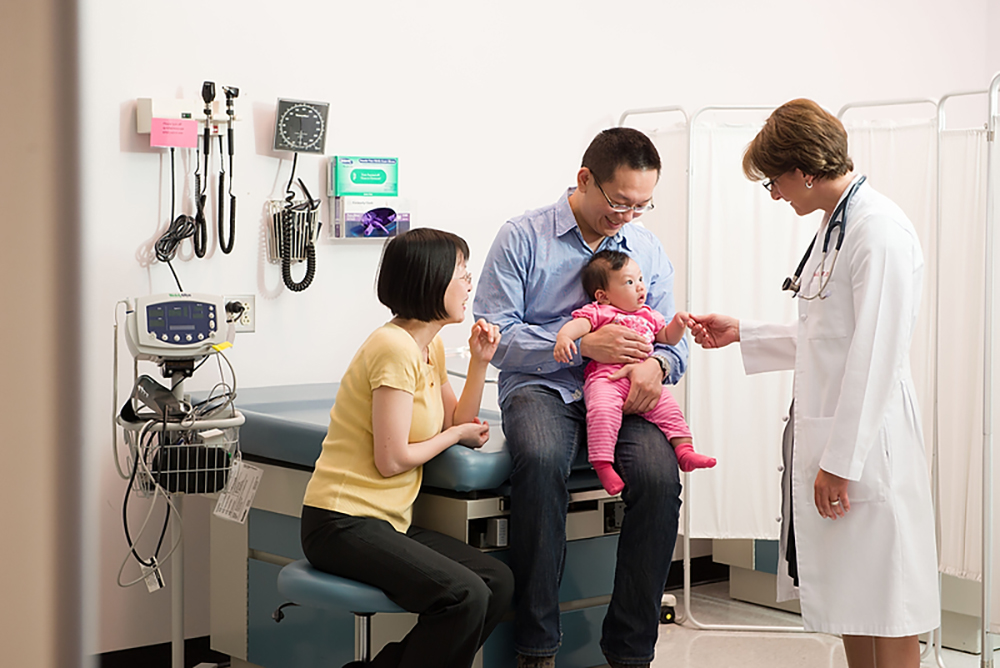 A pediatric acute care nurse meets with a family.