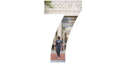 a student walking in front of the building in the shape of a 7