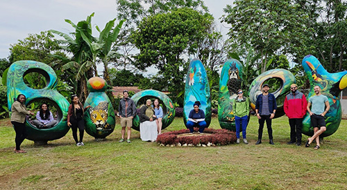 Students standing in front of a sign in costa rica