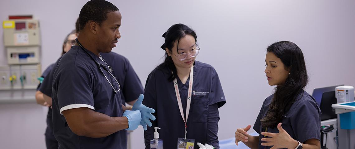 three nursing students in scrubs have a conversation