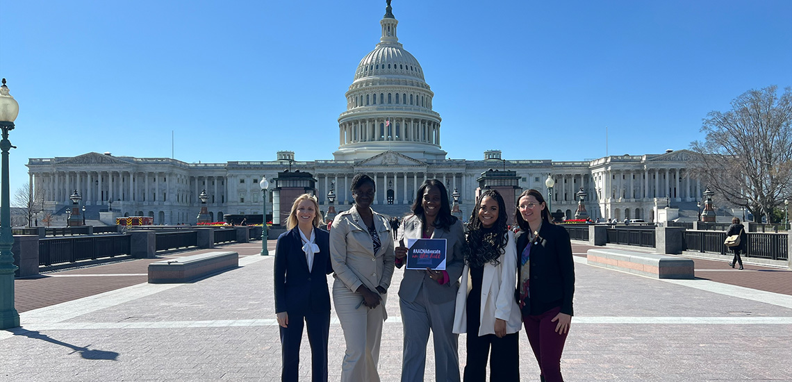 Students and the Dean pose in front of the Capitol building